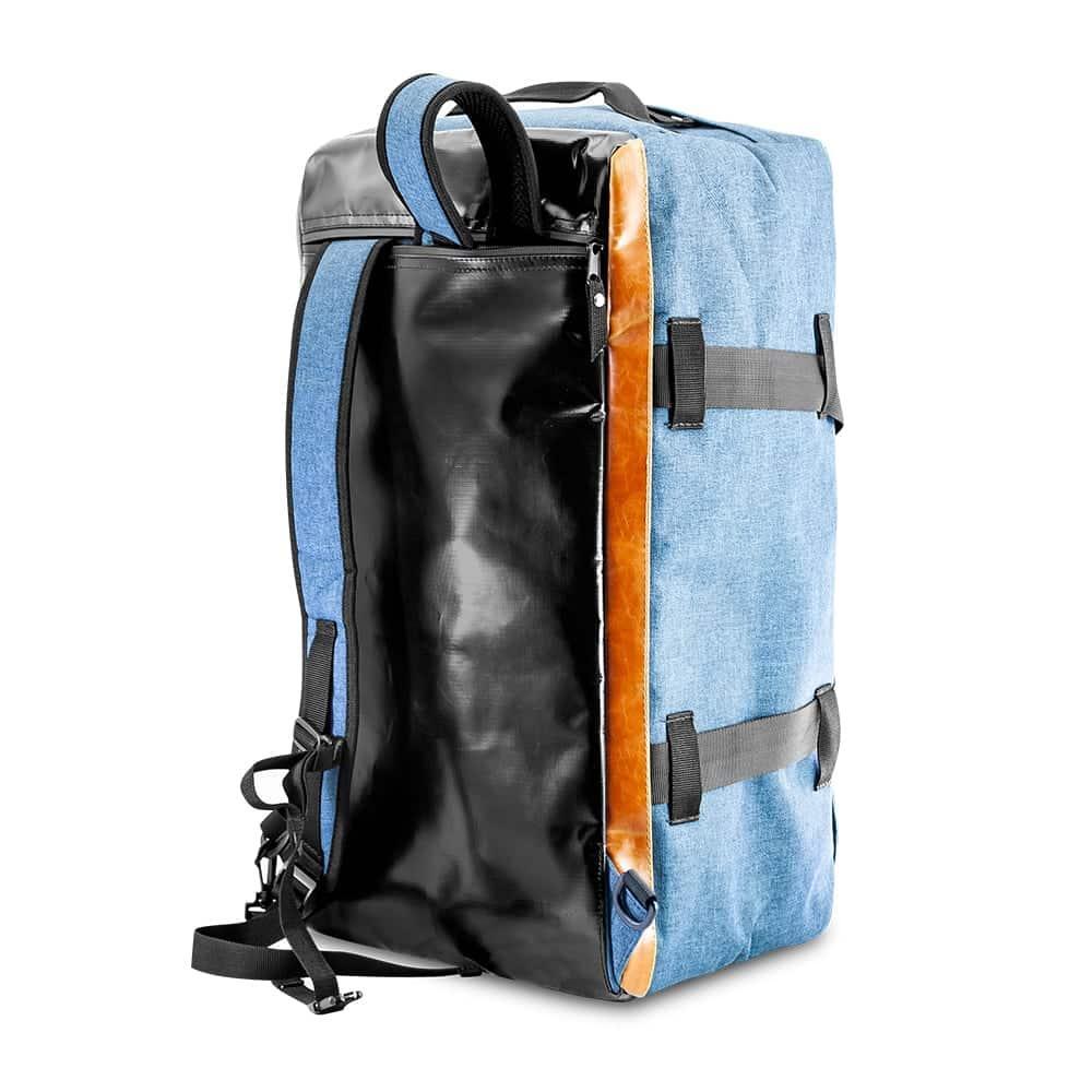 Blue denim and black hybrid duffle bag with shoulder straps, side view