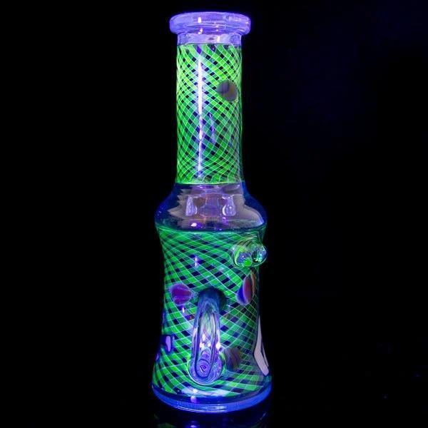 Glowing green and blue heady glass bong with crisscross pattern, UV-reactive design