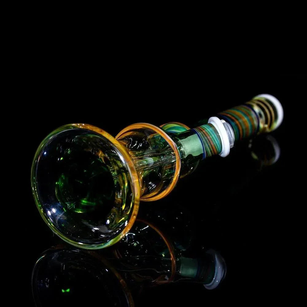 Handblown glass pipe with green and amber swirls, striped stem, on black reflective surface