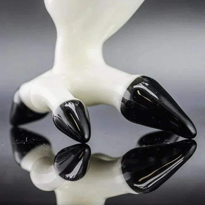 White and black glass pipe with claw-like design, reflective surface