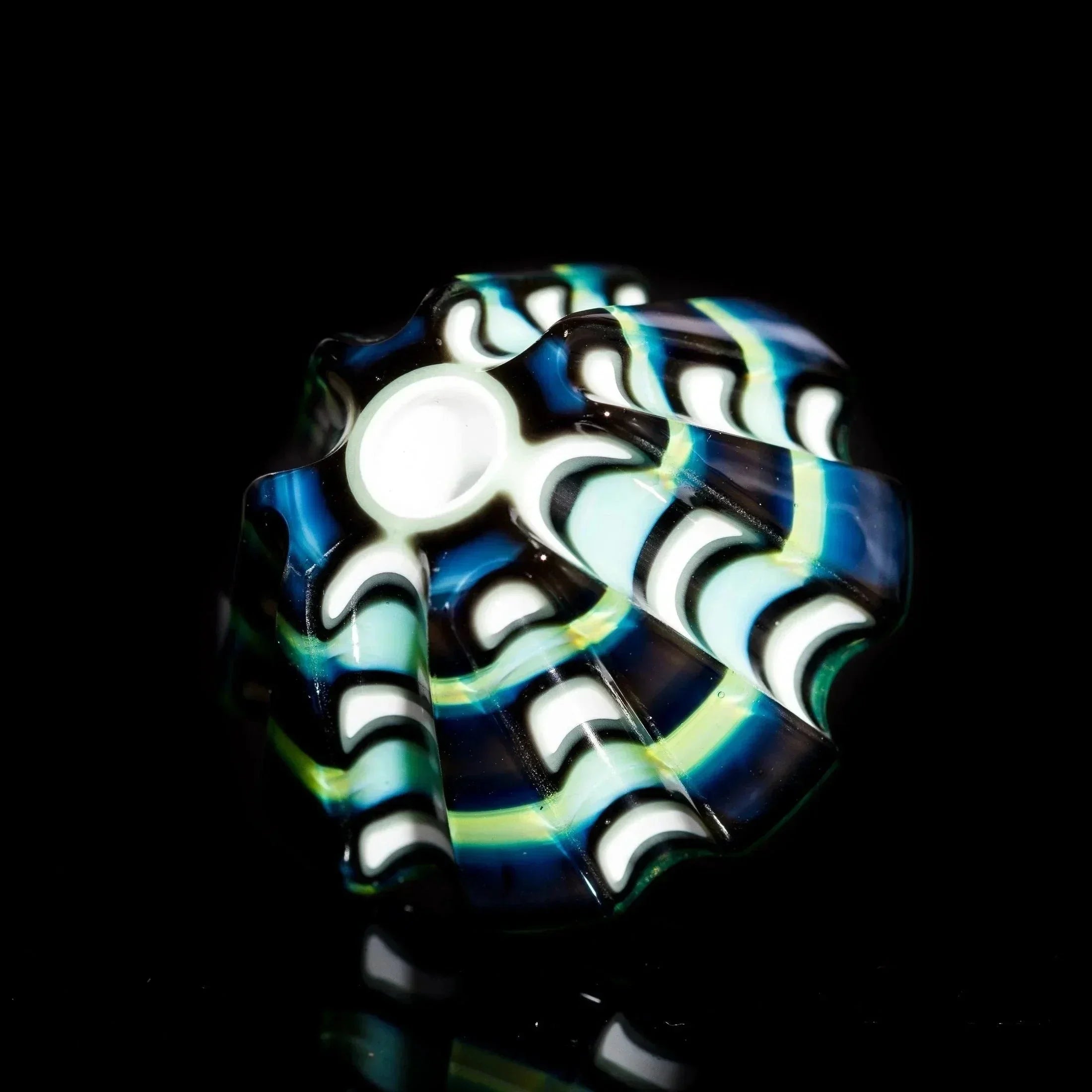 Hand-blown glass pipe with blue, green, and white swirls on black background