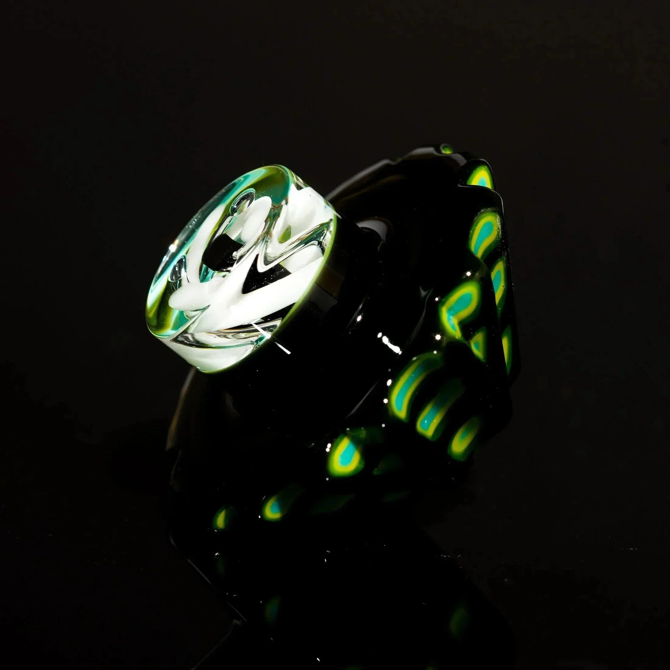 Hand-blown glass pipe with black base, green-yellow swirls, and white floral bowl design