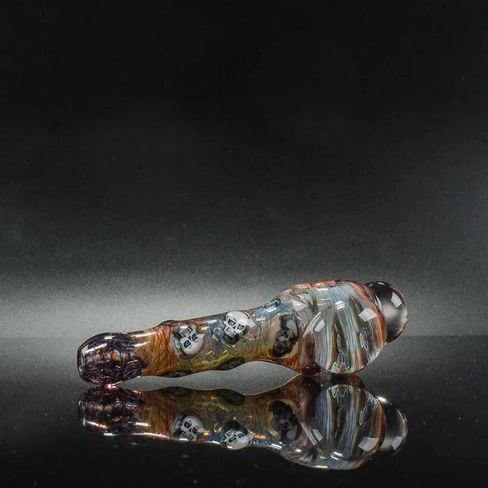 Colorful skull-adorned glass pipe with reflective surface, heady glass art for smoke shop collection