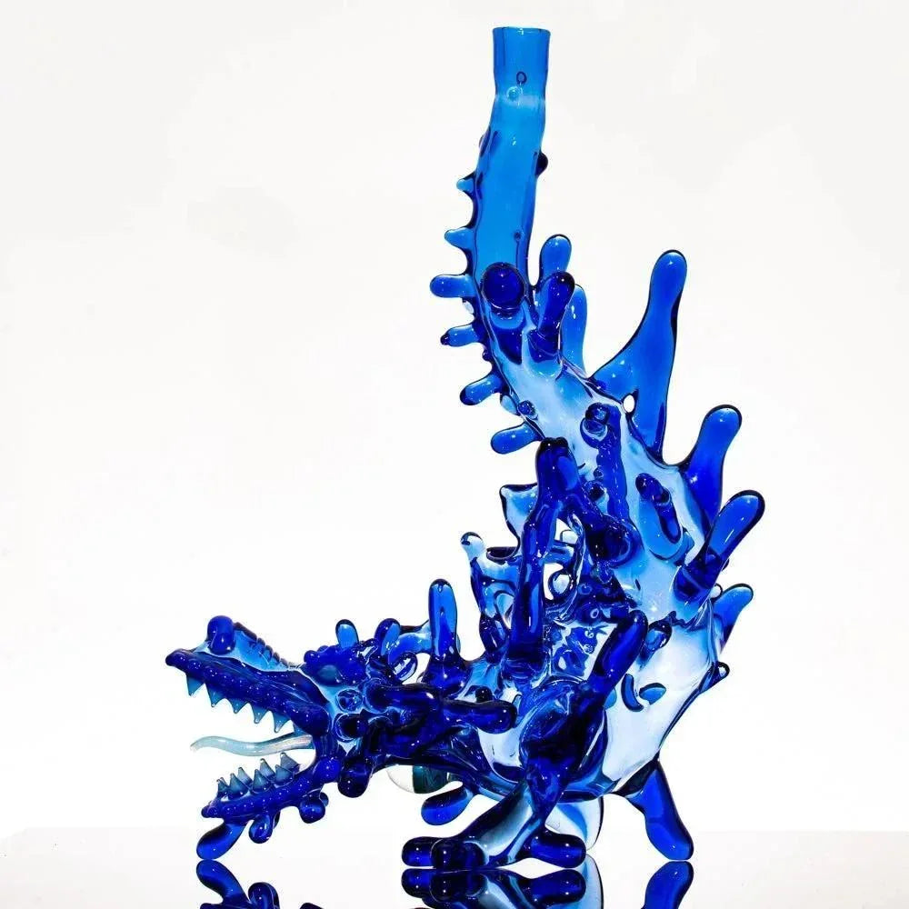 Blue glass dragon bong with intricate scales and spiky details, heady glass art piece