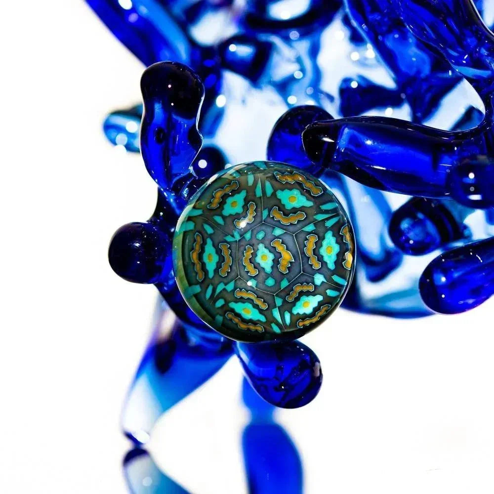Vibrant blue glass sculpture with intricate teal and gold floral patterns, showcasing heady glass artistry.