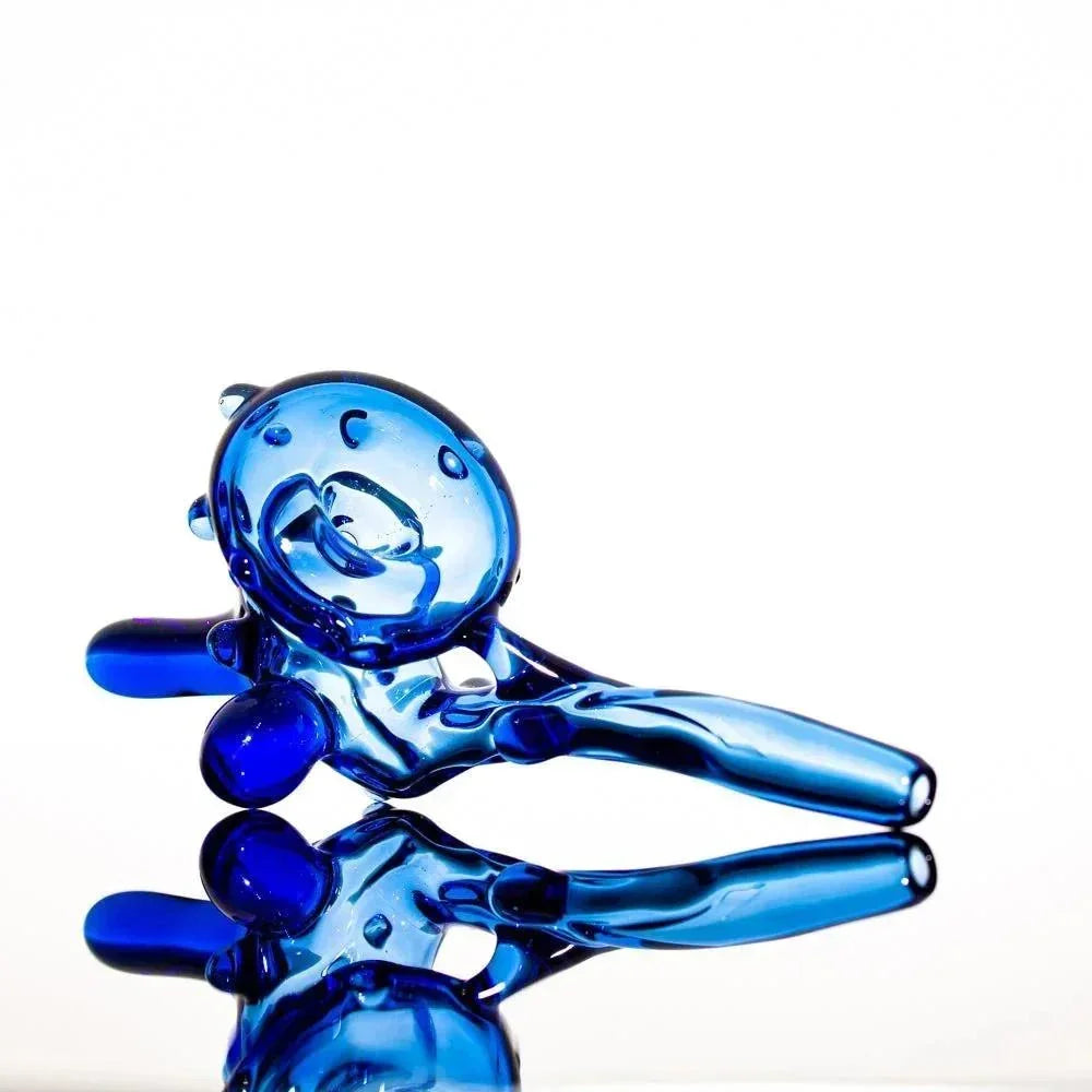 Blue glass pipe with intricate swirls and bubble accents, reflective surface