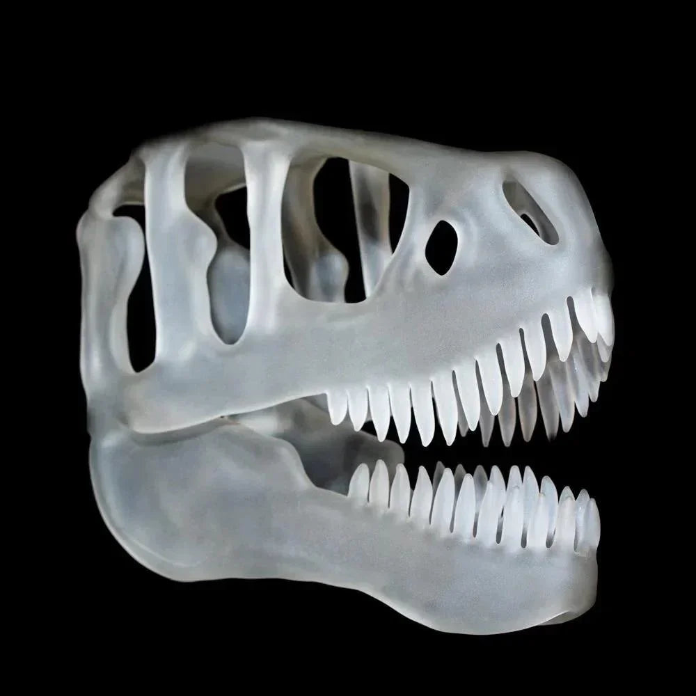 Translucent glass T-Rex skull sculpture with detailed teeth on black background.