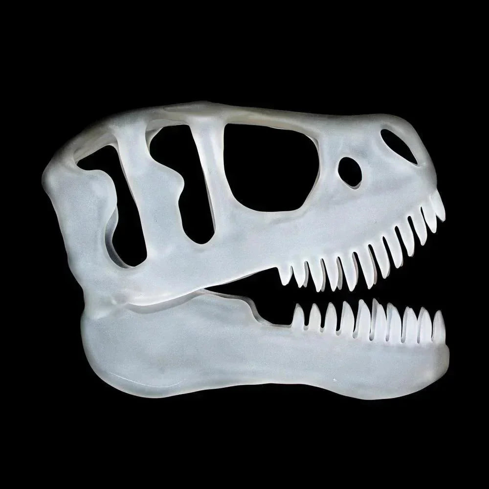 Frosted glass sculpture shaped like a T-Rex dinosaur skull on black background