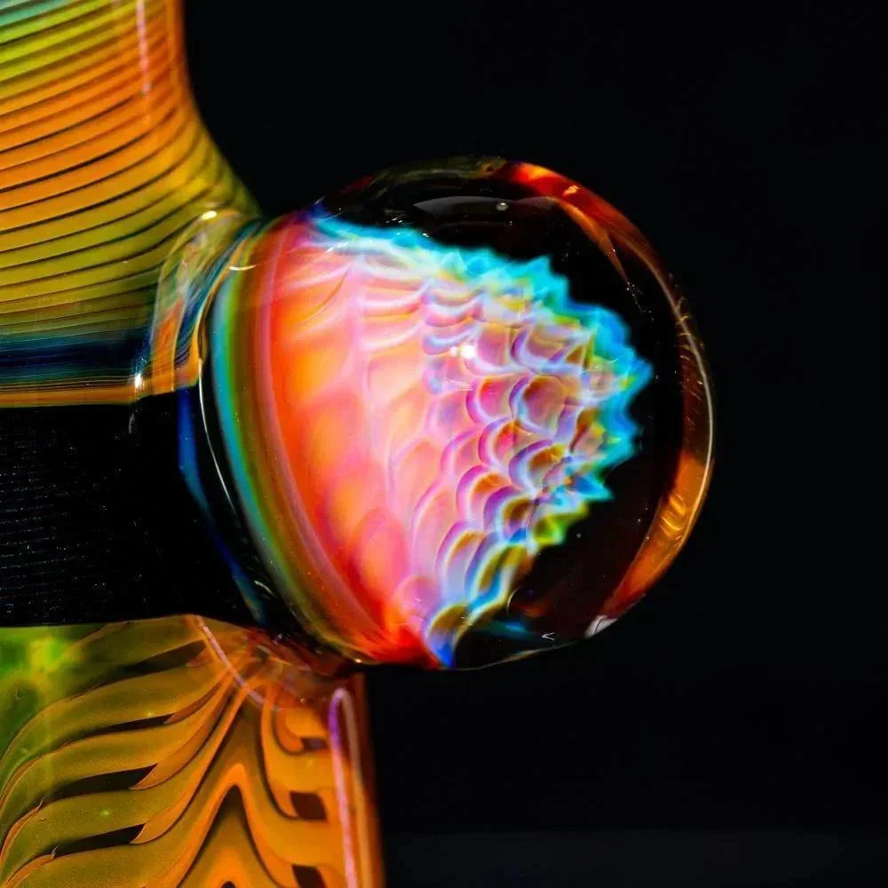 Close-up of intricate glass art detail with rainbow fume pattern on a colorful water pipe