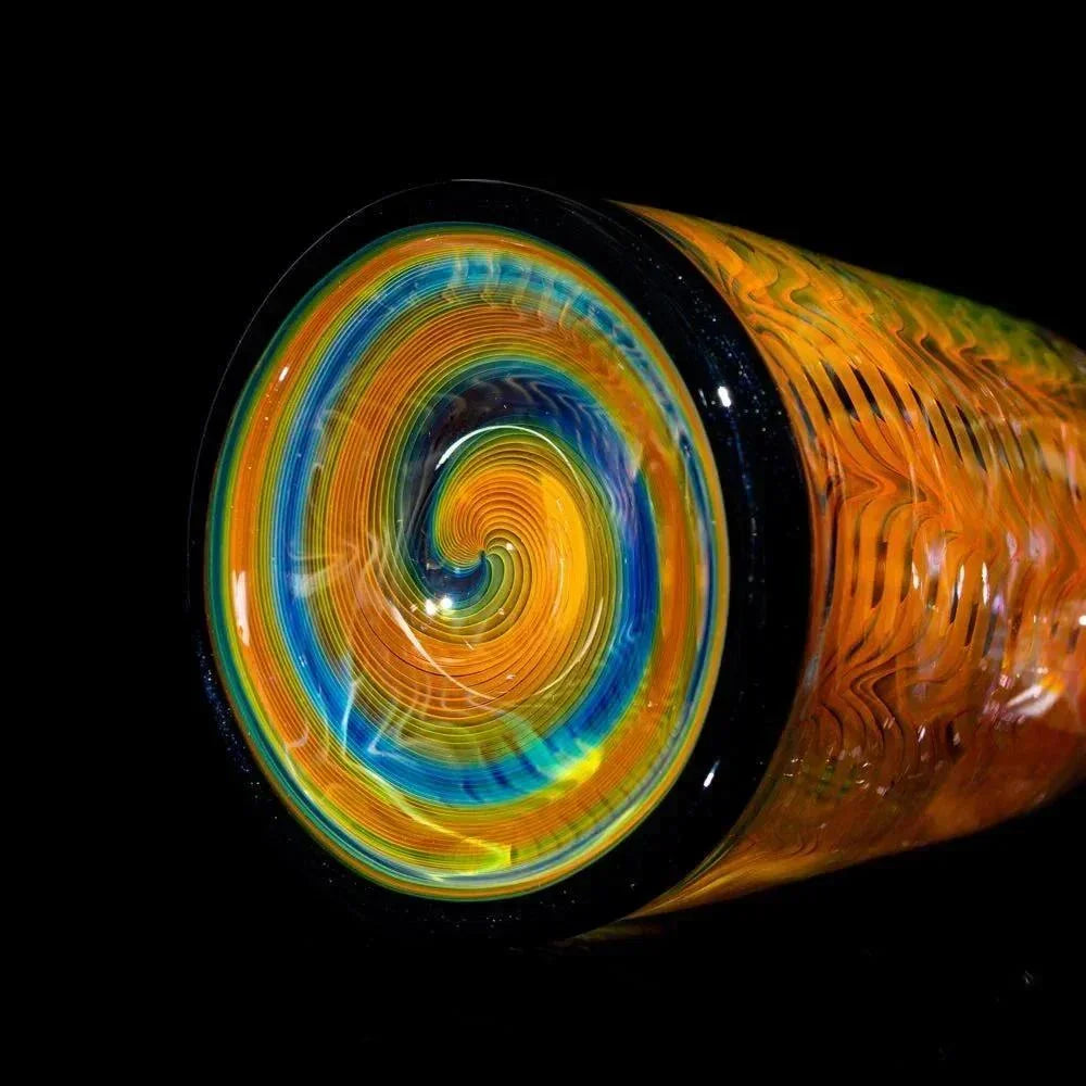 Close-up of colorful glass tube base with intricate orange and blue spiral pattern
