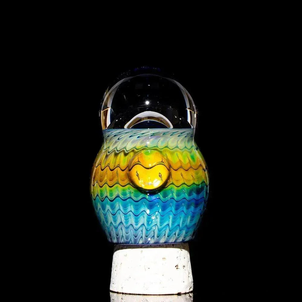 Colorful hand-blown glass jar with cobalt and fume accents against a black background