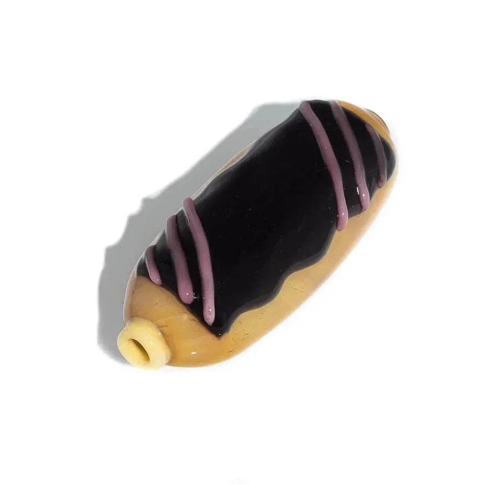 Glass pipe shaped like a chocolate eclair pastry with purple drizzle on white background