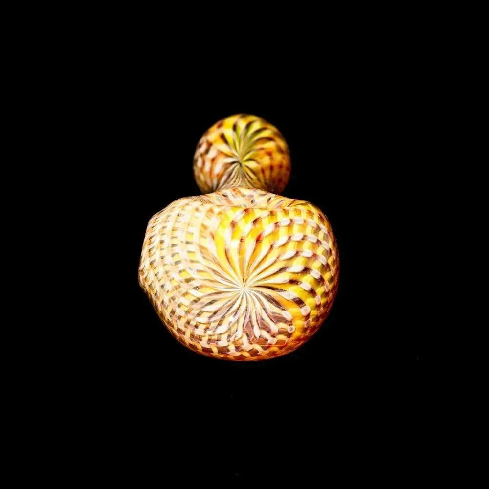 Yellow retti glass spoon pipe with intricate spiral design on black background