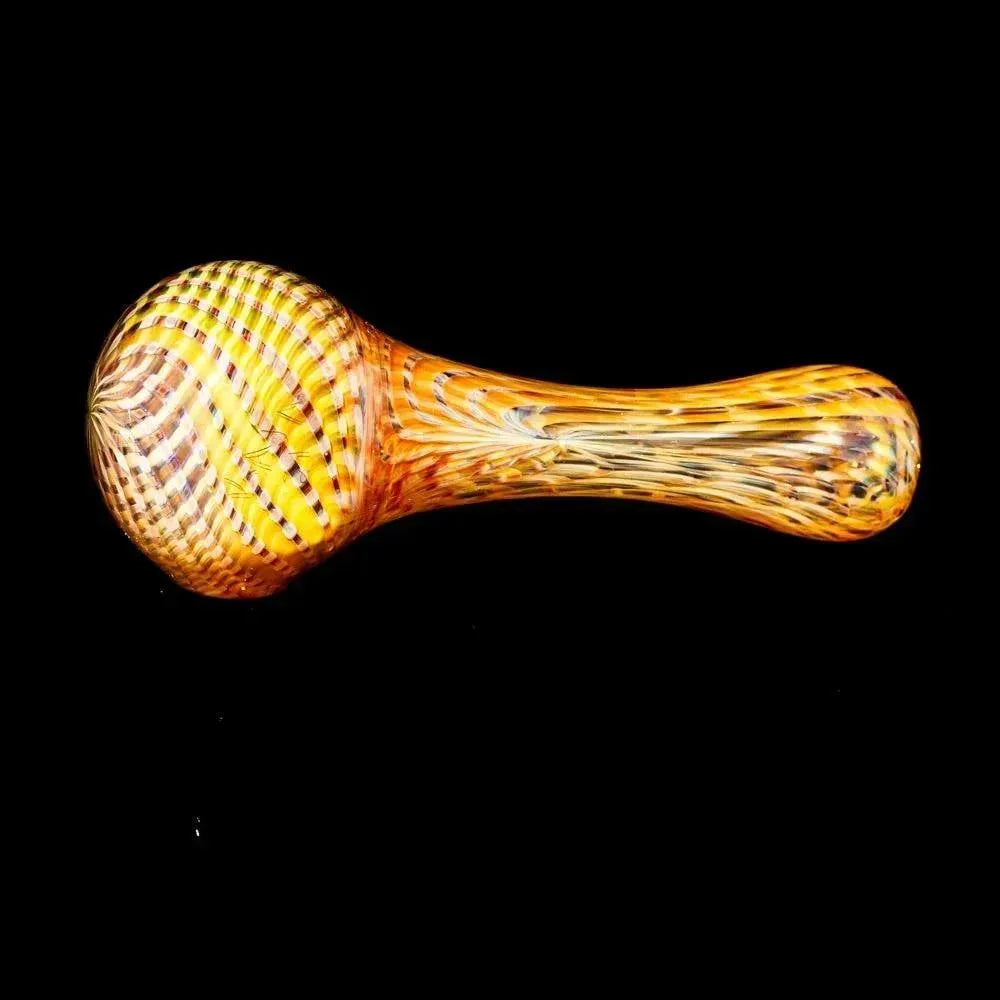Yellow reticello glass hand pipe with intricate patterns on black background