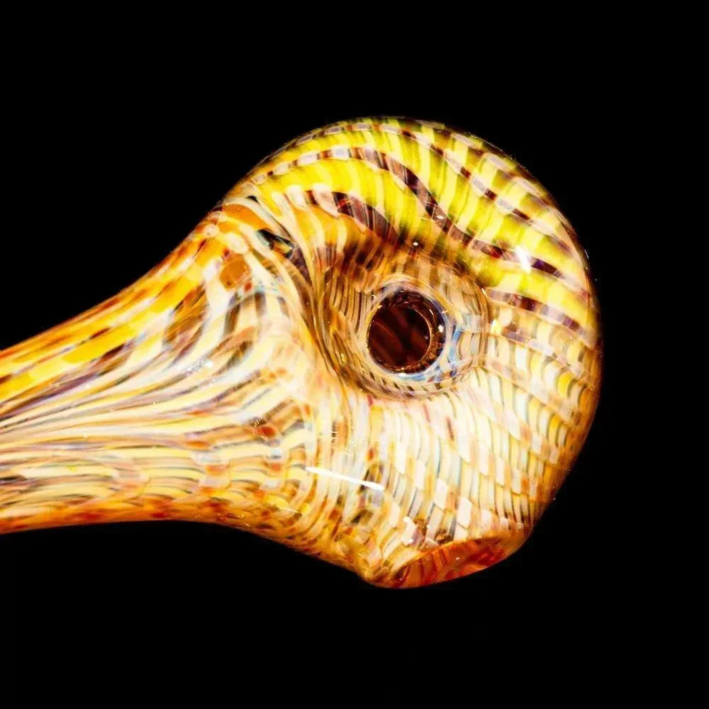Yellow and amber striped glass hand pipe with retti pattern on black background