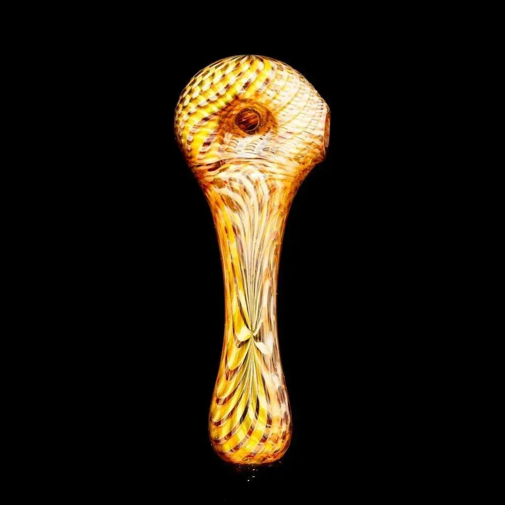Yellow glass hand pipe with swirling retti pattern on a black background