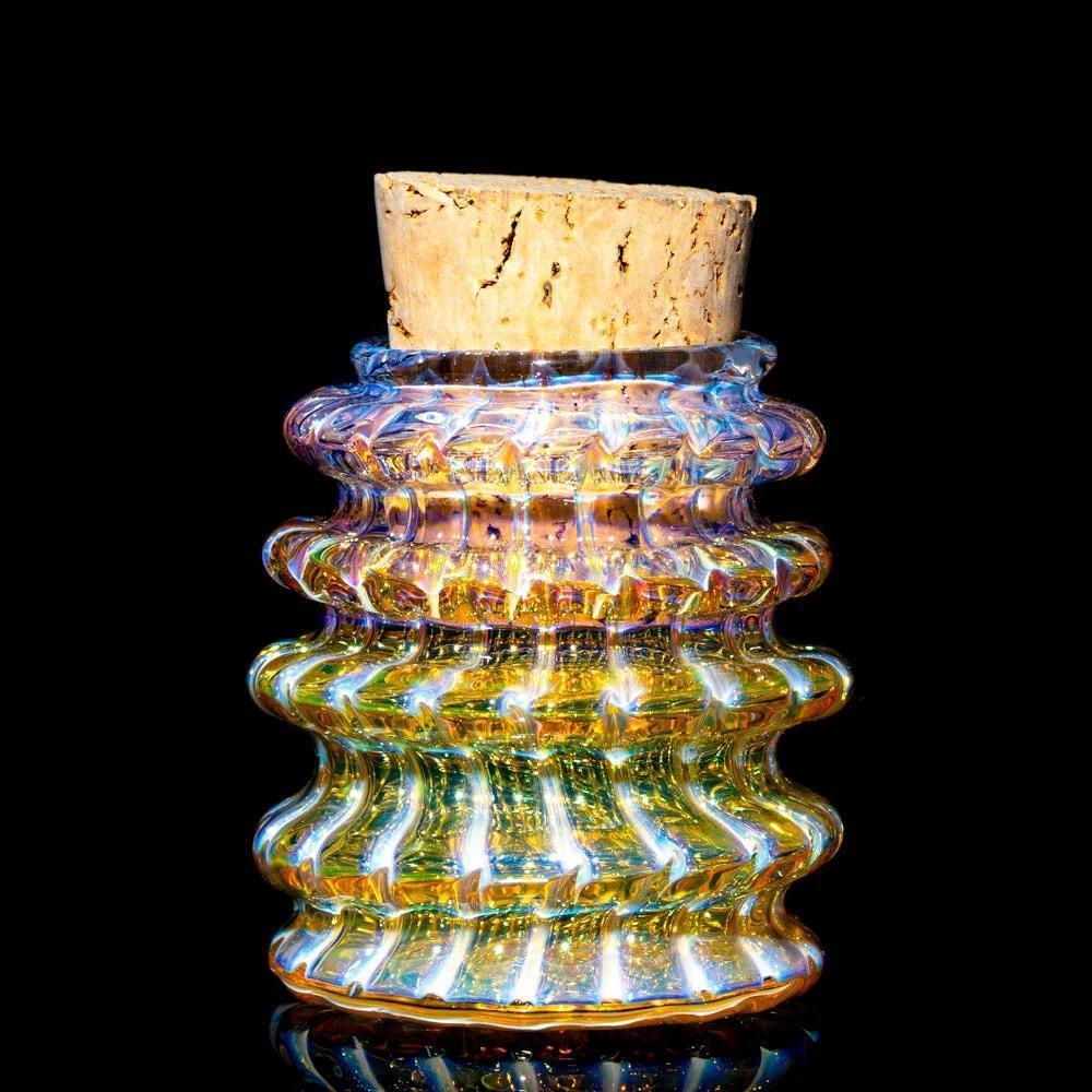 Iridescent wavy glass stash jar with cork lid on black background