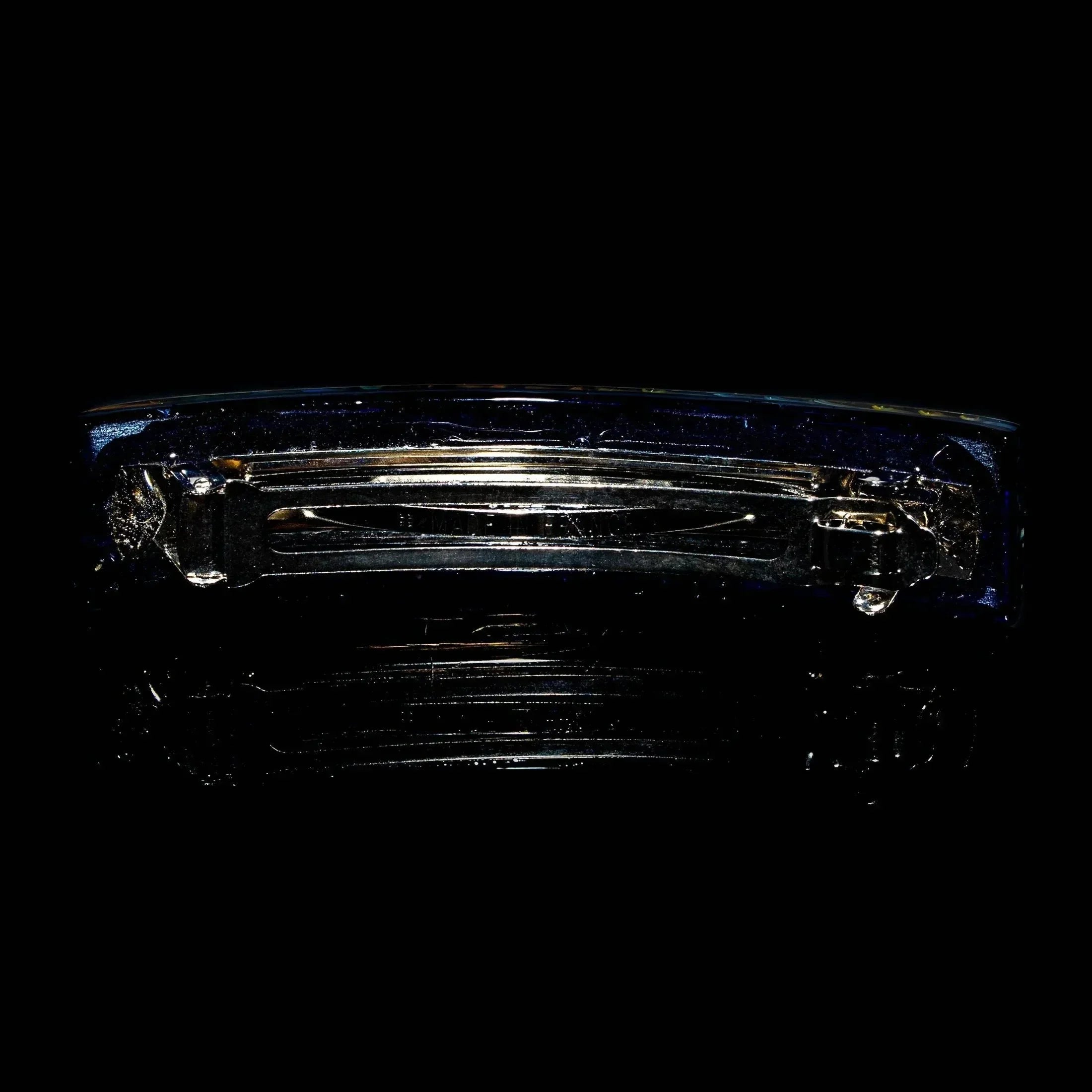 Handcrafted glass hair barrette with silver clasp on black background