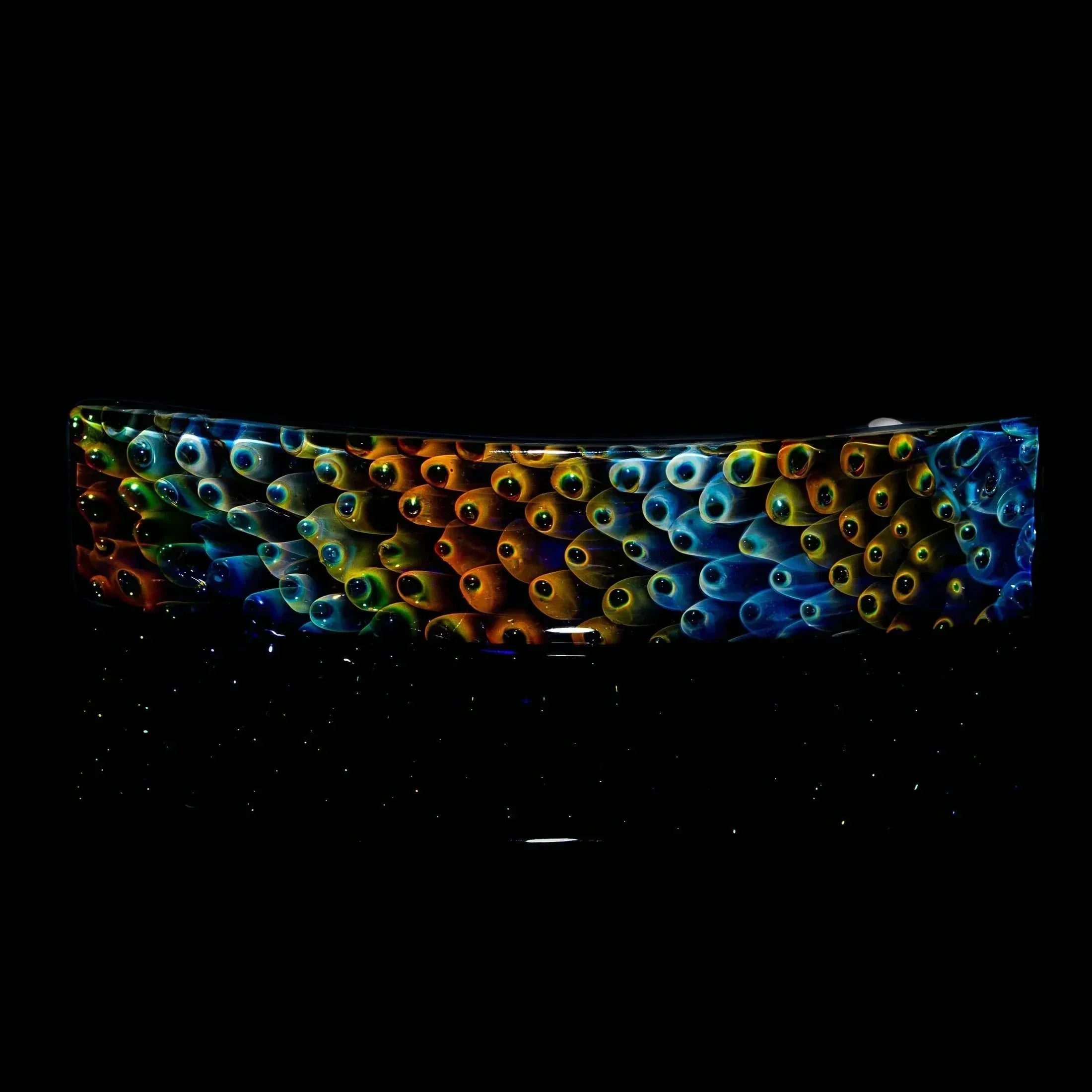 Colorful handmade glass barrette with ocean-inspired eye pattern on black background
