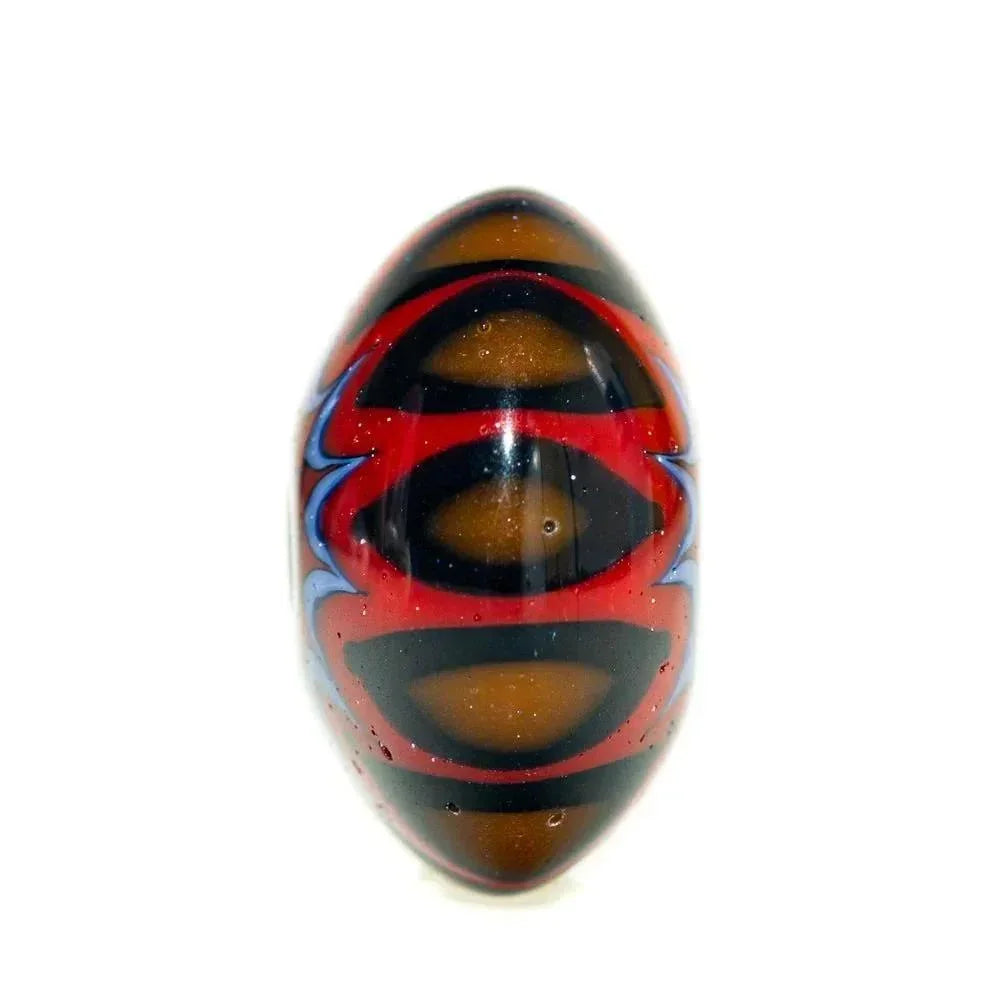 Handmade glass lentil bead with red, black, blue chevron patterns on white background