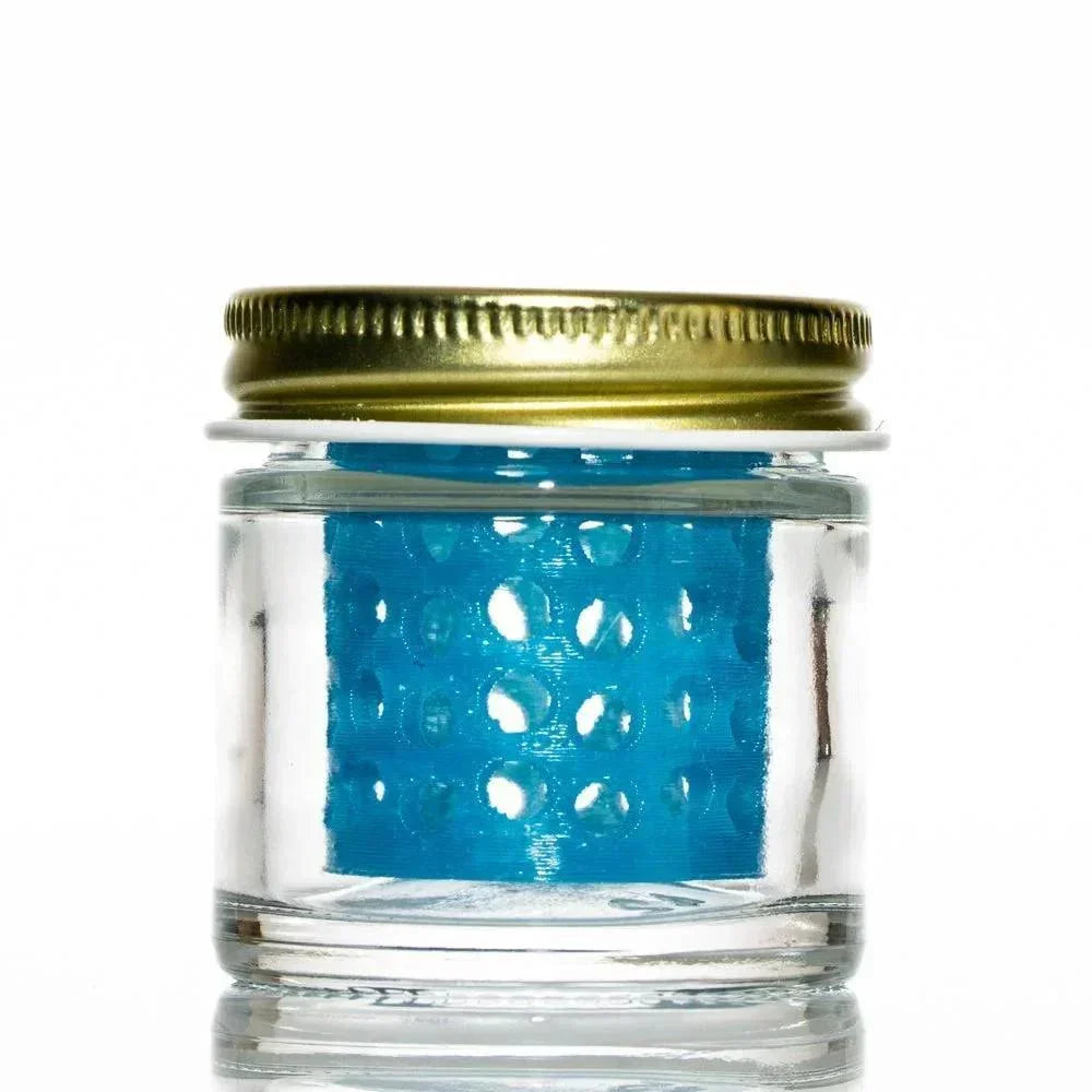 Glass jar with gold lid containing blue perforated insert, used for cleaning glass pieces