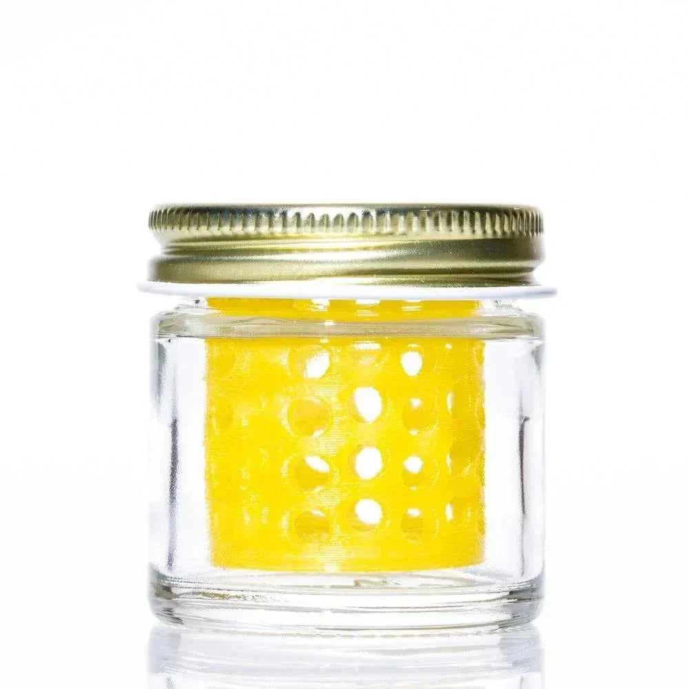 Clear glass jar with gold lid containing yellow perforated insert for glass cleaning