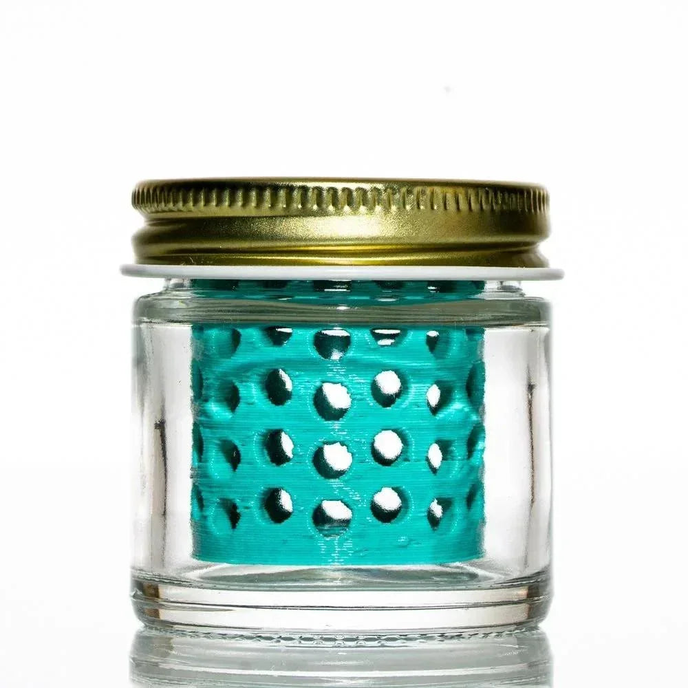 Glass jar with gold lid and teal perforated insert for washing glass pieces