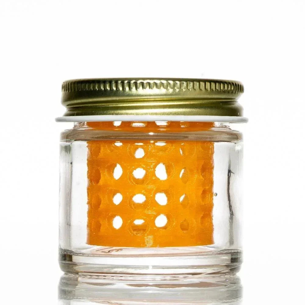 Clear glass jar with metal lid and orange perforated insert for glass accessory cleaning