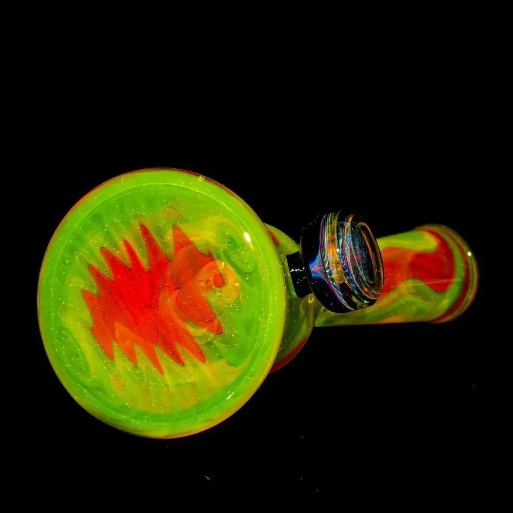 Colorful glass pipe with lime green, yellow, and red swirl design on black background