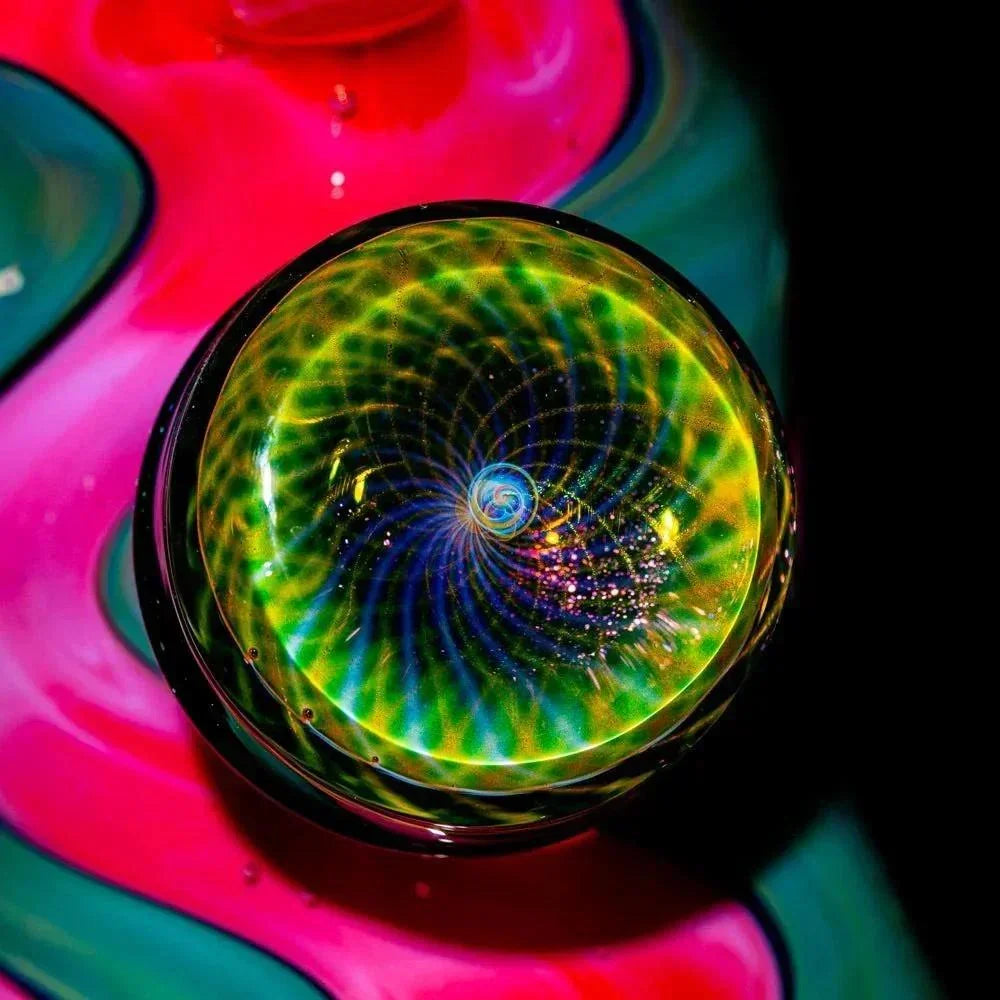 Handblown glass pipe with a vibrant spiral eye marble and swirling pink, green accents