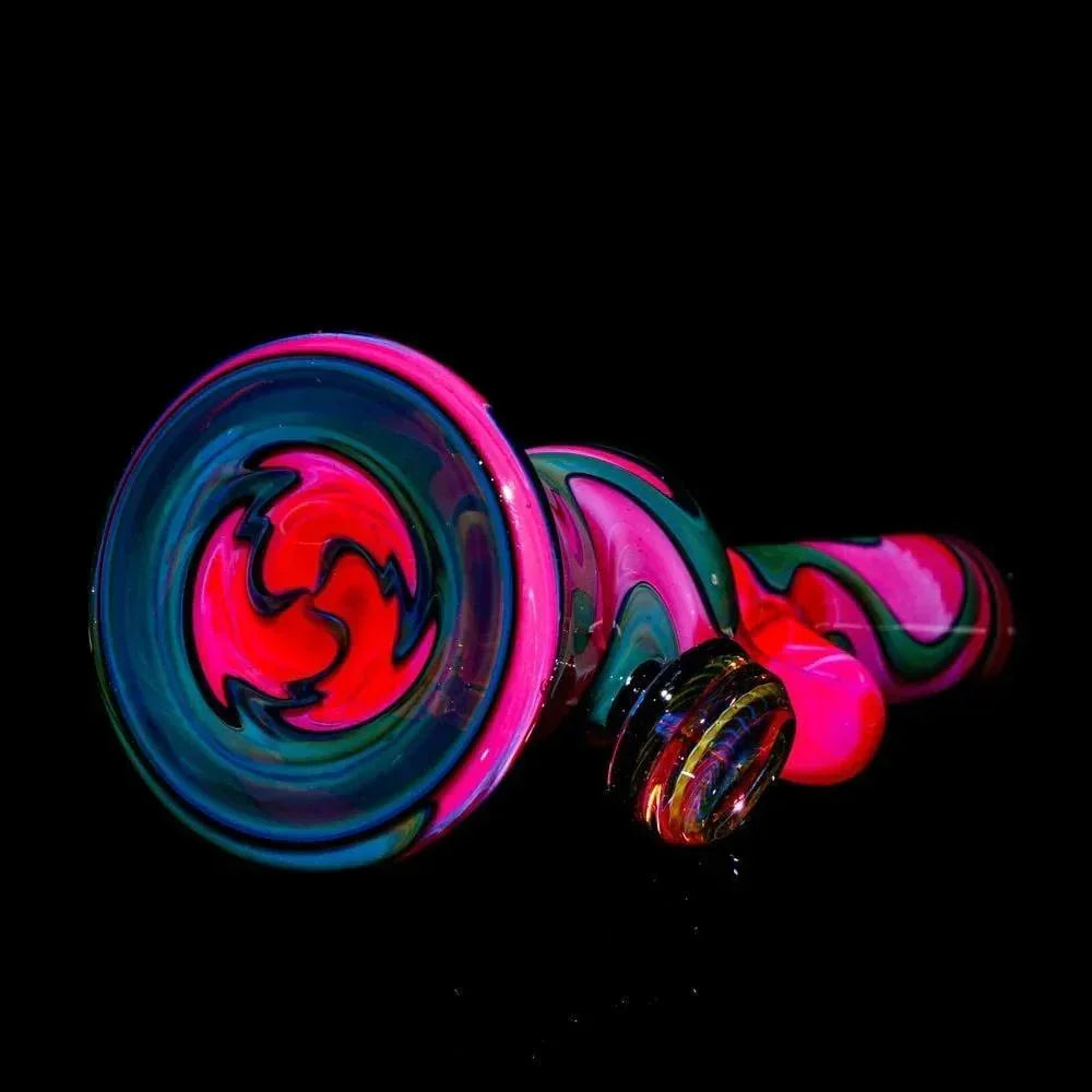 Pink, green, and blue heady glass pipe with swirling lava pattern on black background