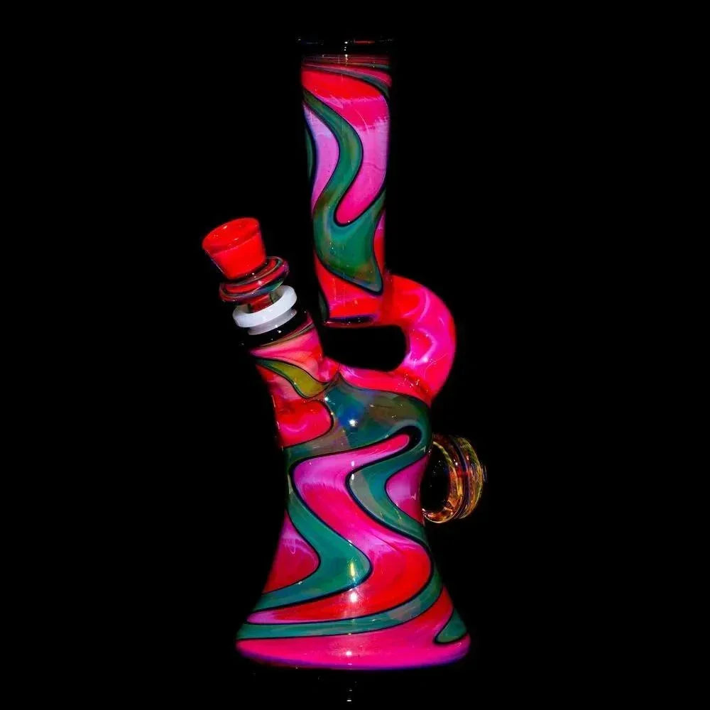 Colorful heady glass water pipe with pink, green, and black swirled patterns on black background