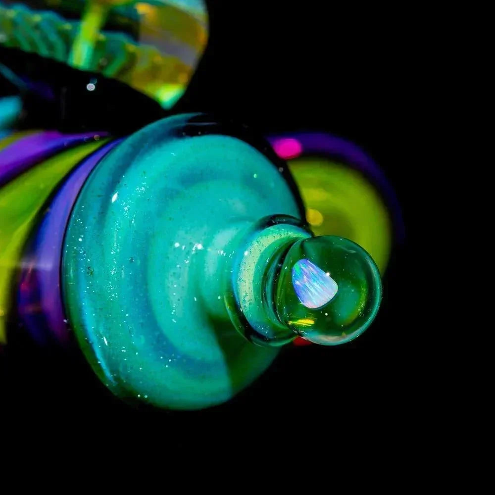 Close-up of a vibrant, multicolored glass art pipe with swirling patterns and opal accent.