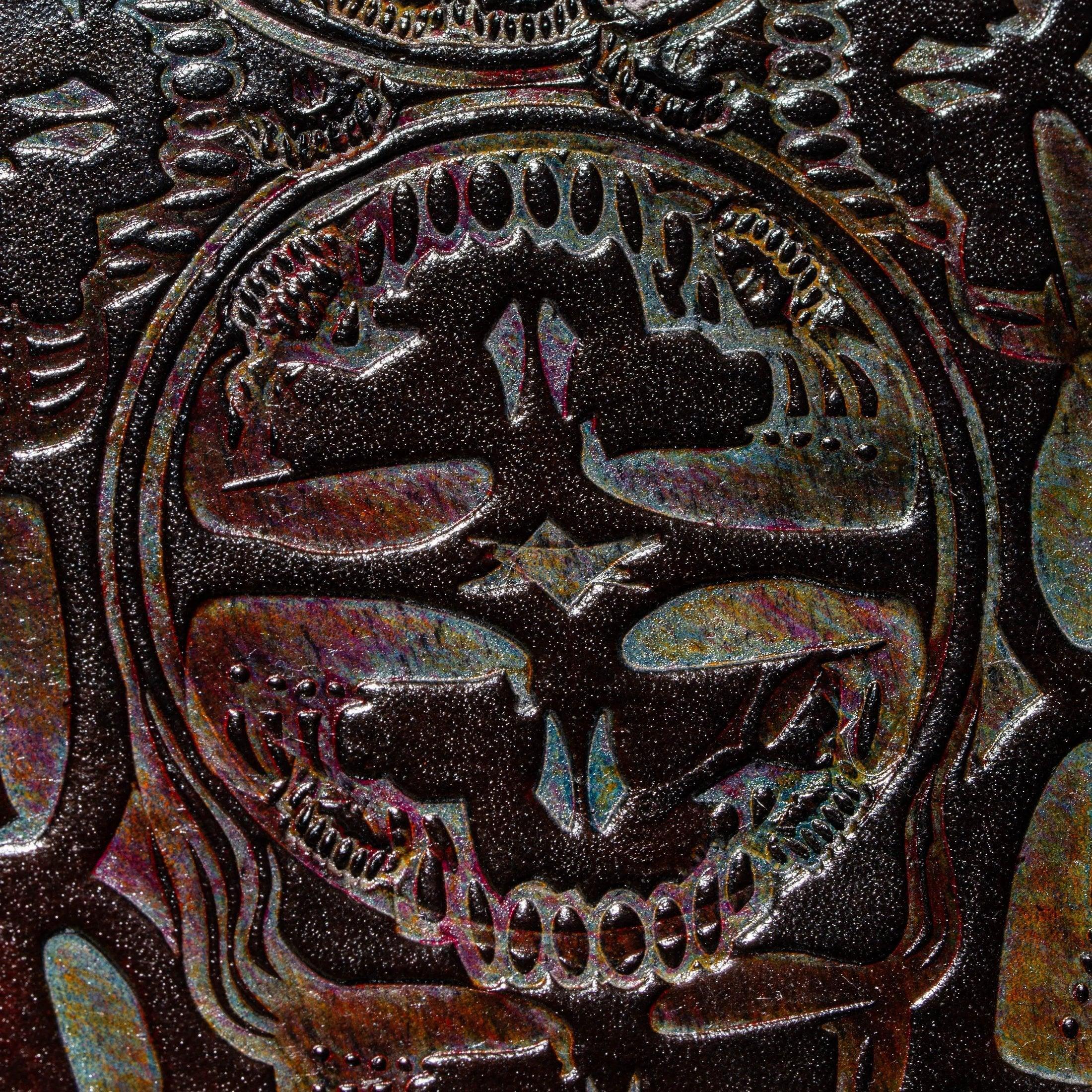 Close-up of embossed leather with iridescent skull design, textured surface detail.