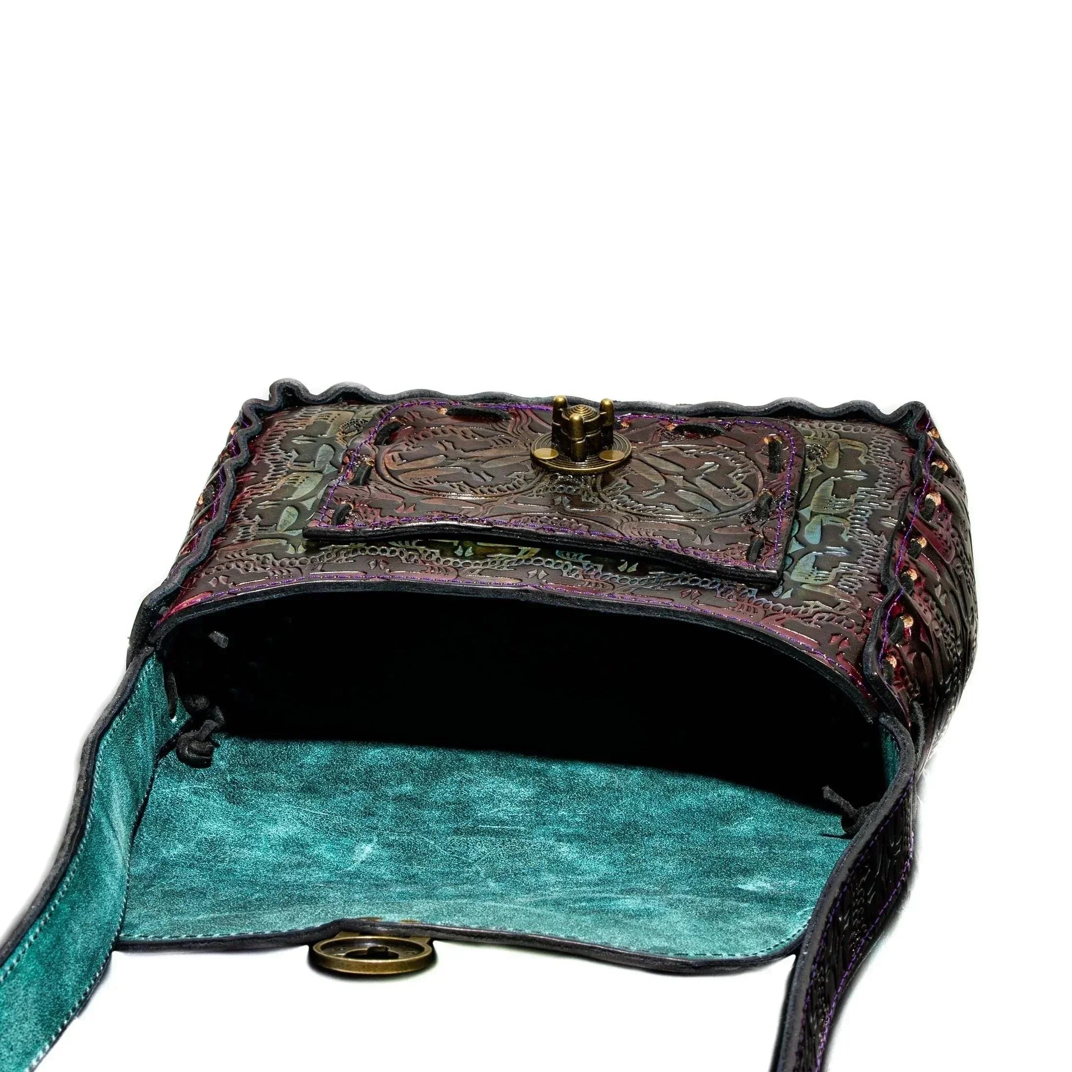 Handmade leather side bag with engraved details and open teal suede interior