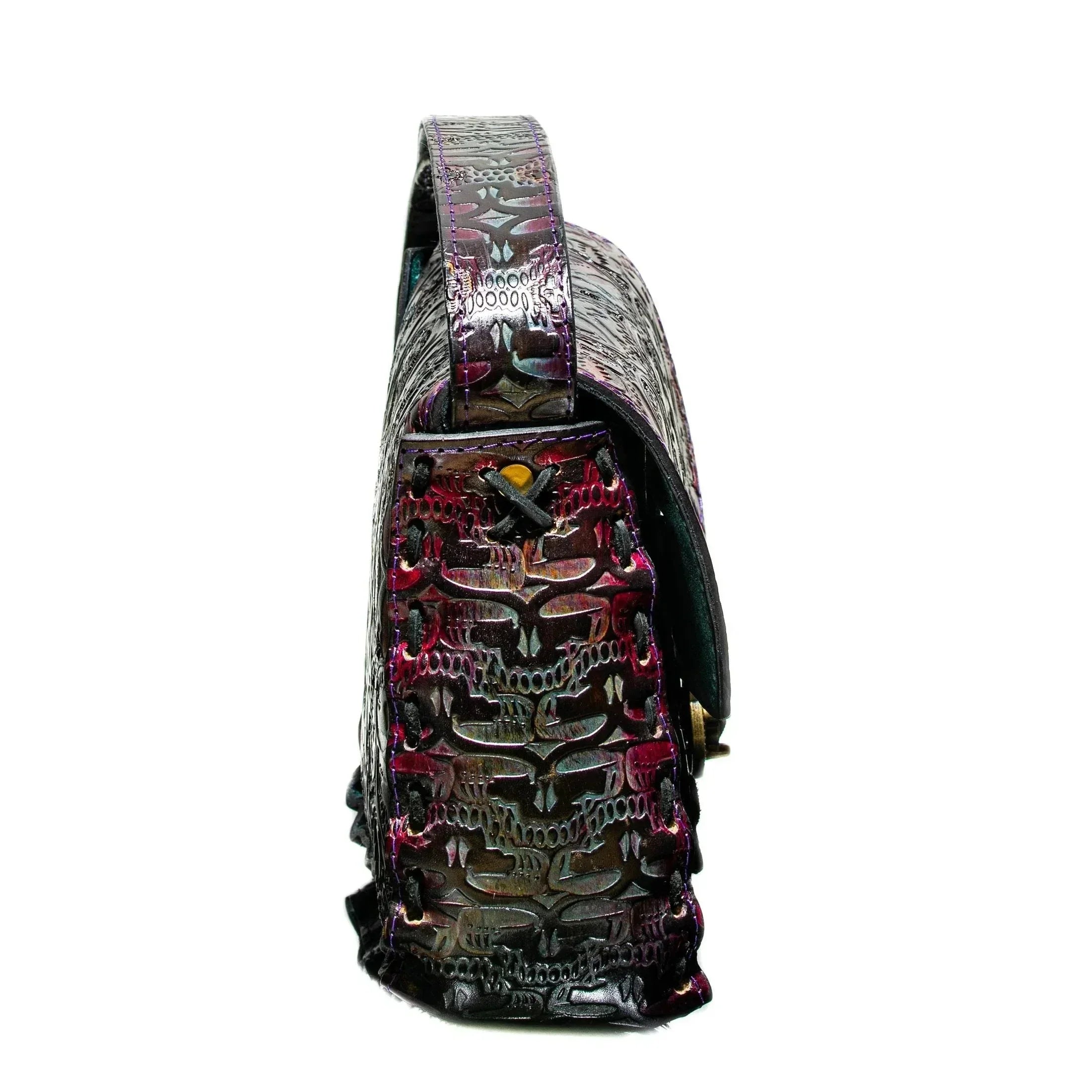 Side view of a handcrafted leather bag with embossed patterns and purple accents