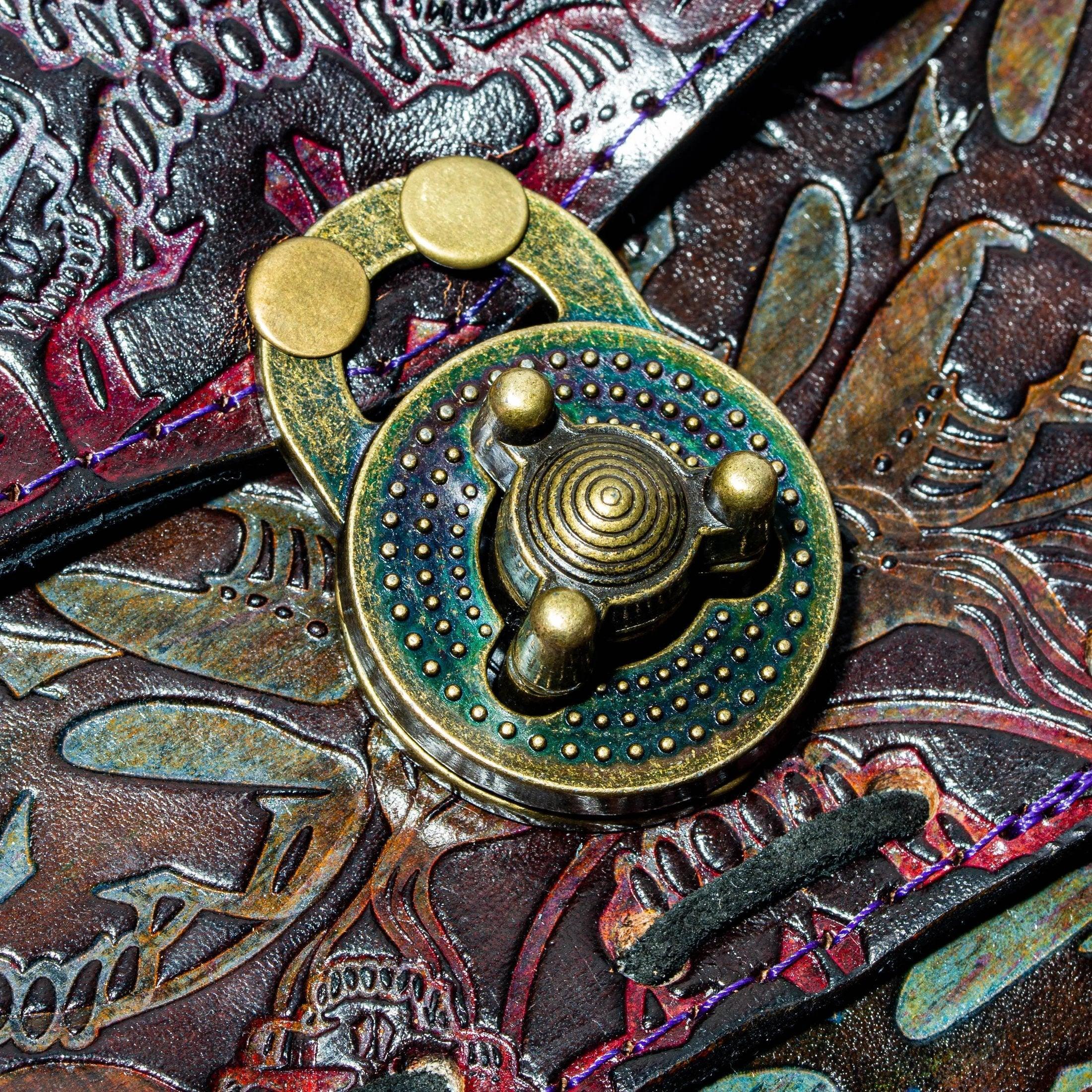 Close-up of embossed leather bag with decorative brass latch and intricate designs