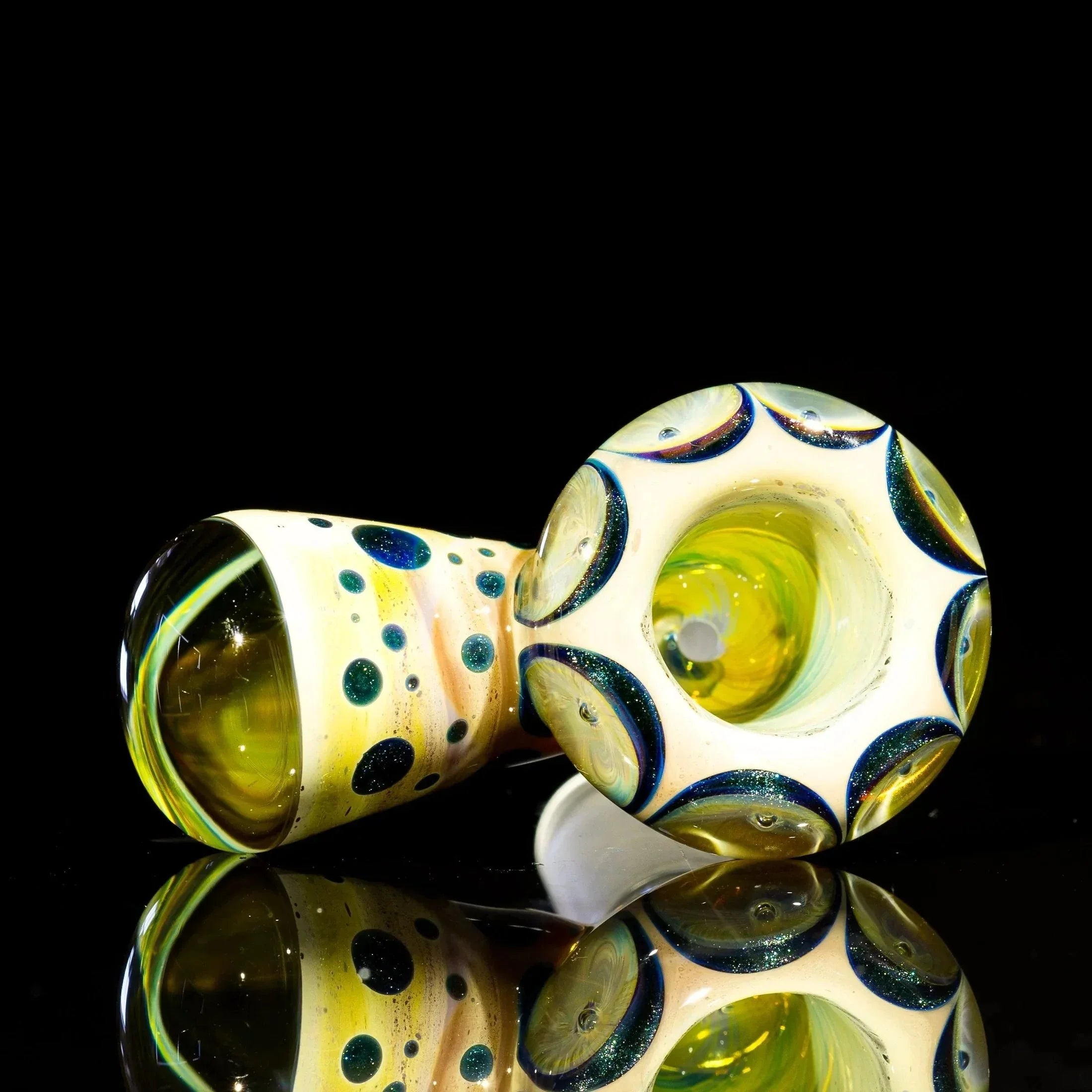 Colorful glass bowl slide with blue and caramel swirl accents on black reflective surface