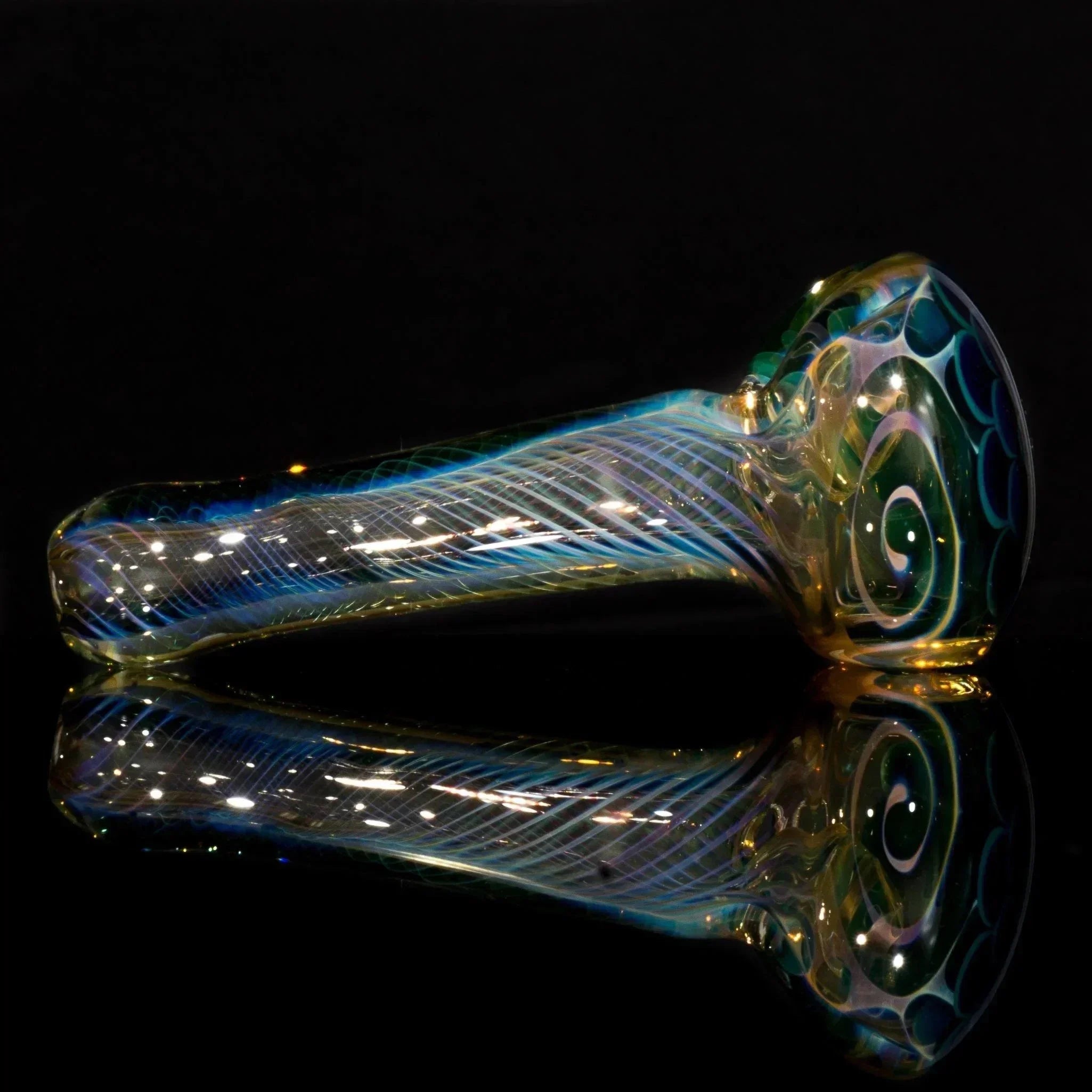 Hand-blown glass pipe with iridescent swirls and intricate patterns, displayed on reflective black surface