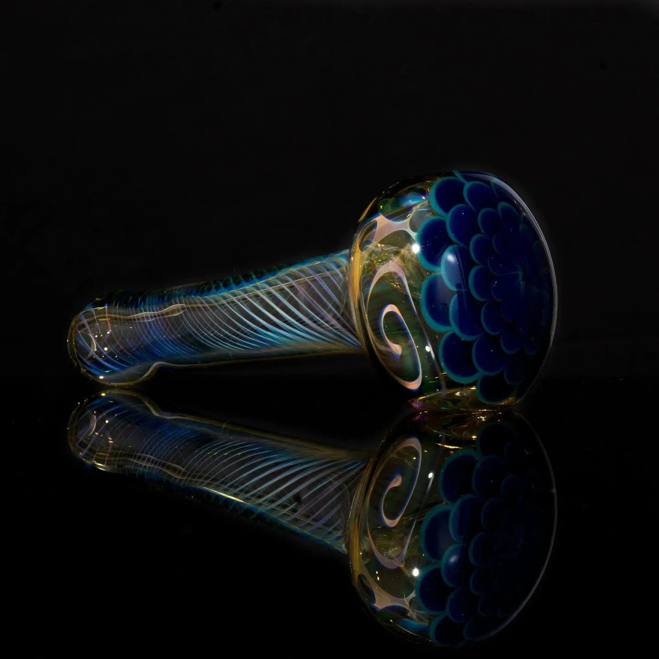 Hand-blown glass pipe with blue swirls and floral design, reflective surface, heady glass art