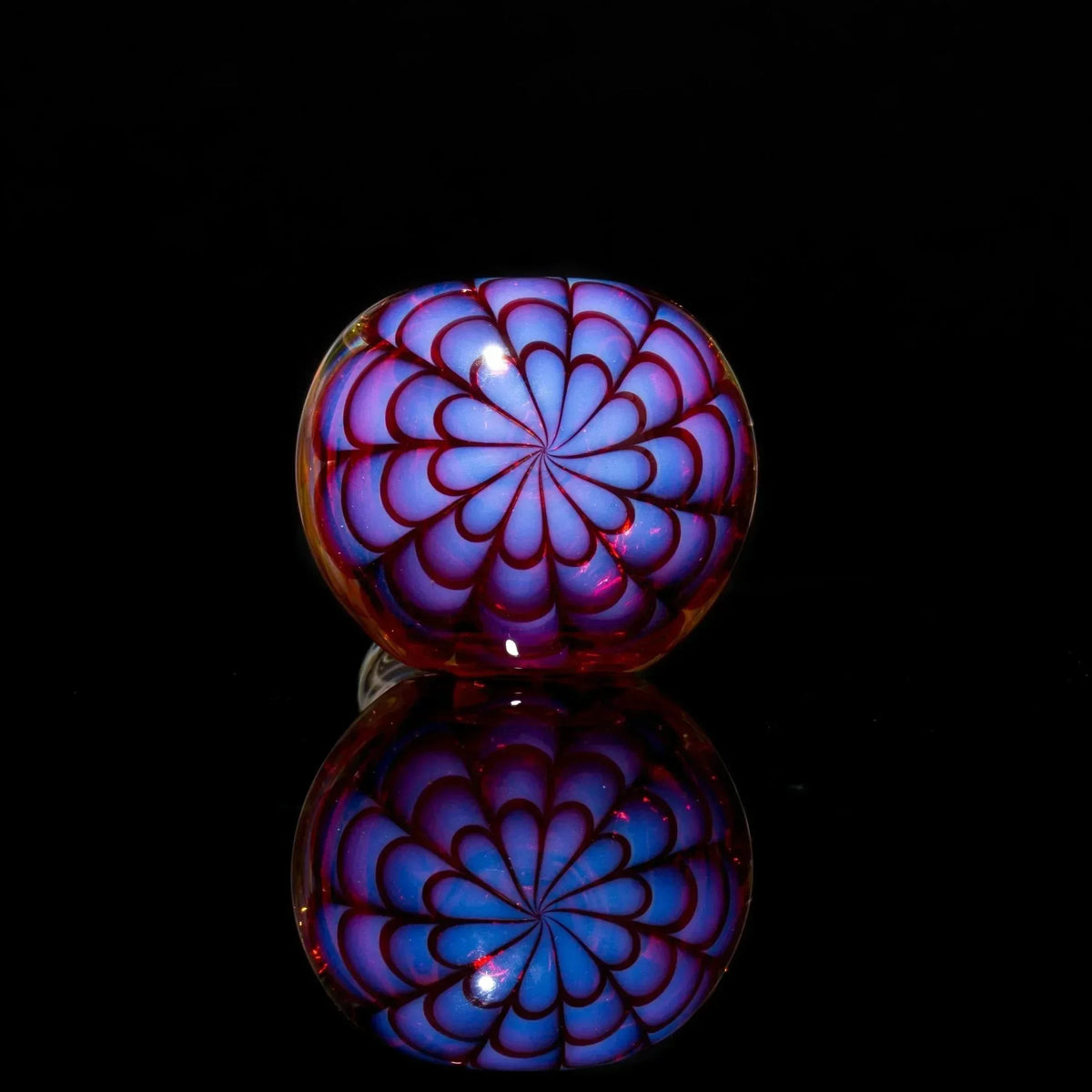 Vibrant blue and red glass pipe bowl with intricate floral pattern, reflective surface, heady glass art