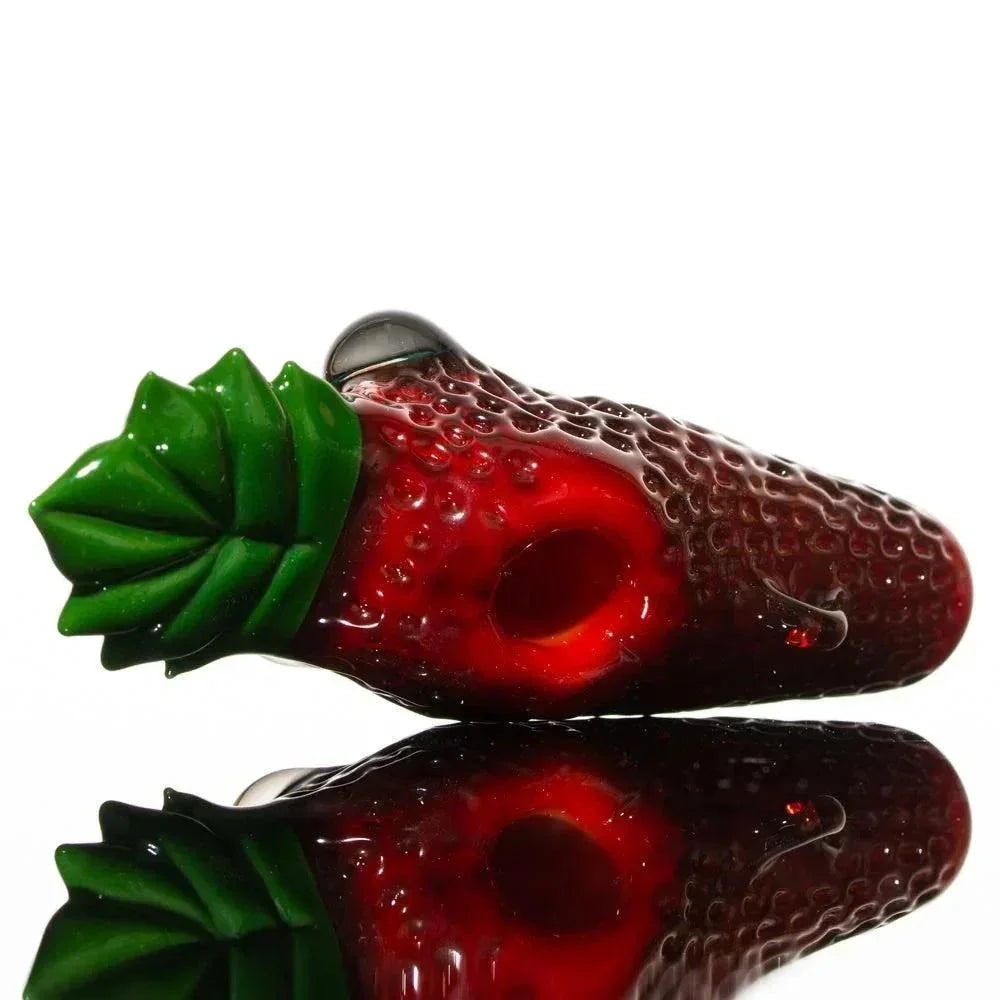 Handcrafted glass pipe shaped like a realistic red strawberry with green leaf details