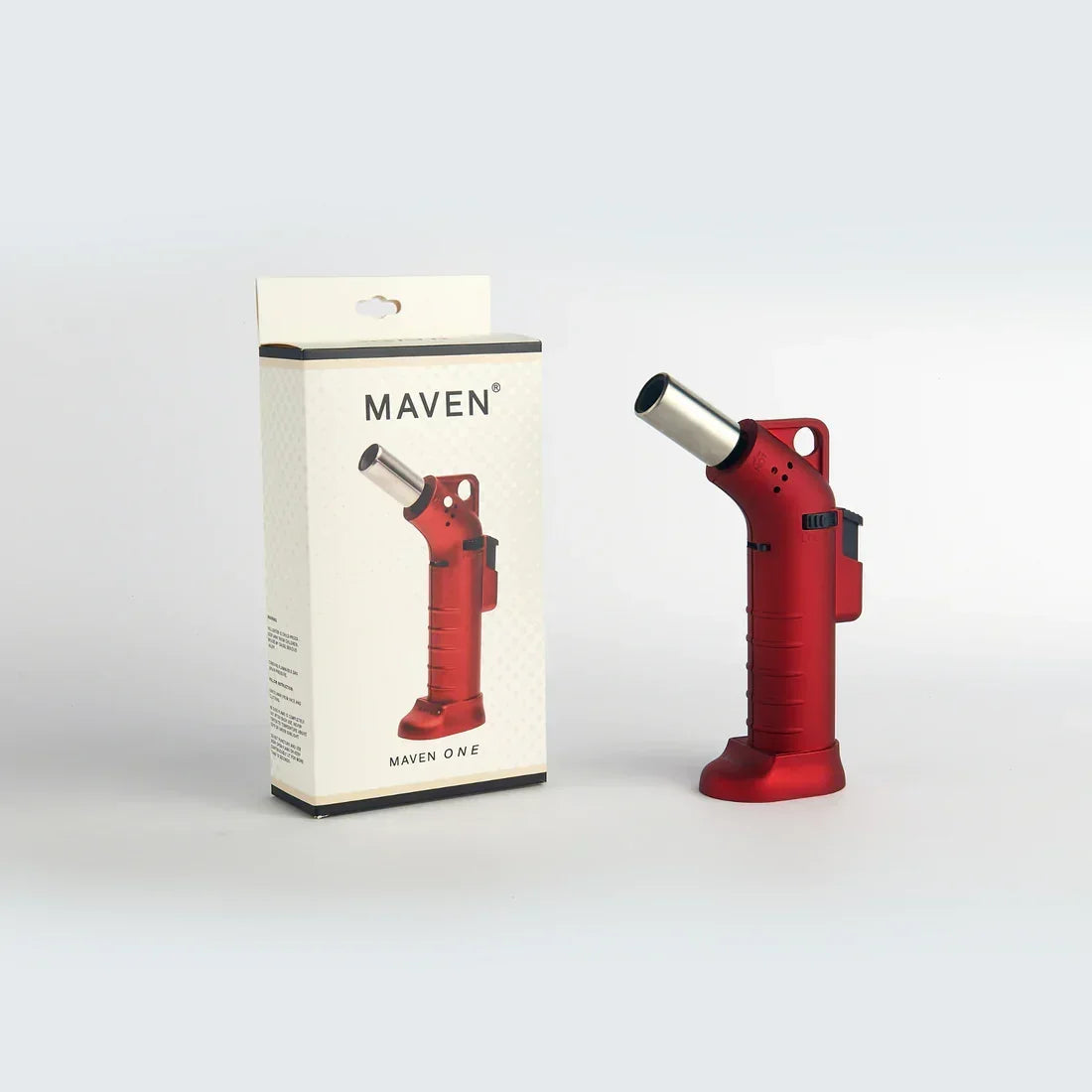 Red butane torch lighter next to its packaging for smoking and glass accessory use