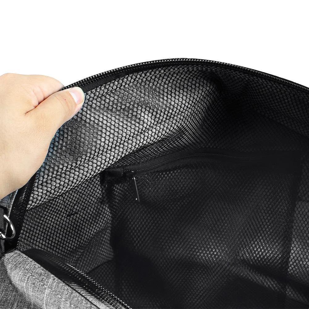 Hand opening gray duffel bag showing mesh pocket and zippered interior compartment