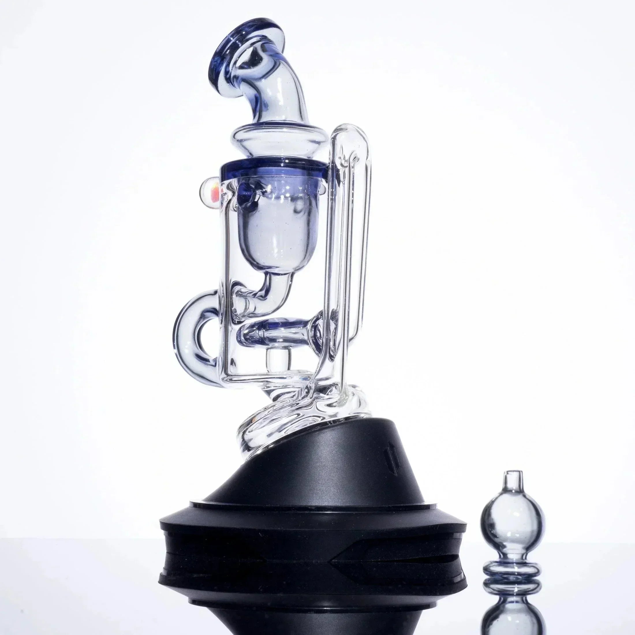 Blue-tinted glass bong with intricate design and black base, ideal for heady glass collectors.
