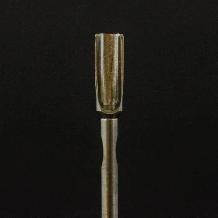 Wooden concentrate sauce scoop tool with grooved tip against a black background