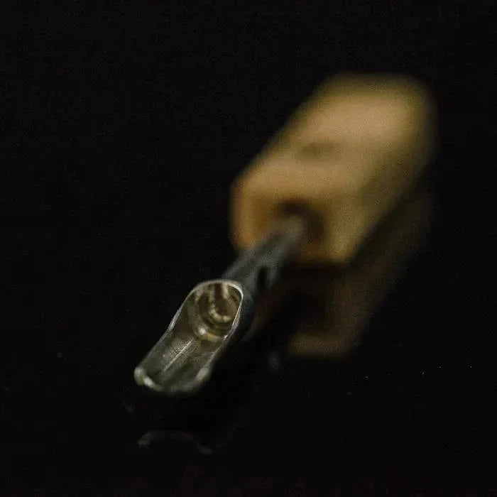 Close-up of a sauce scoop dabber tool with metal tip and wooden handle on black background