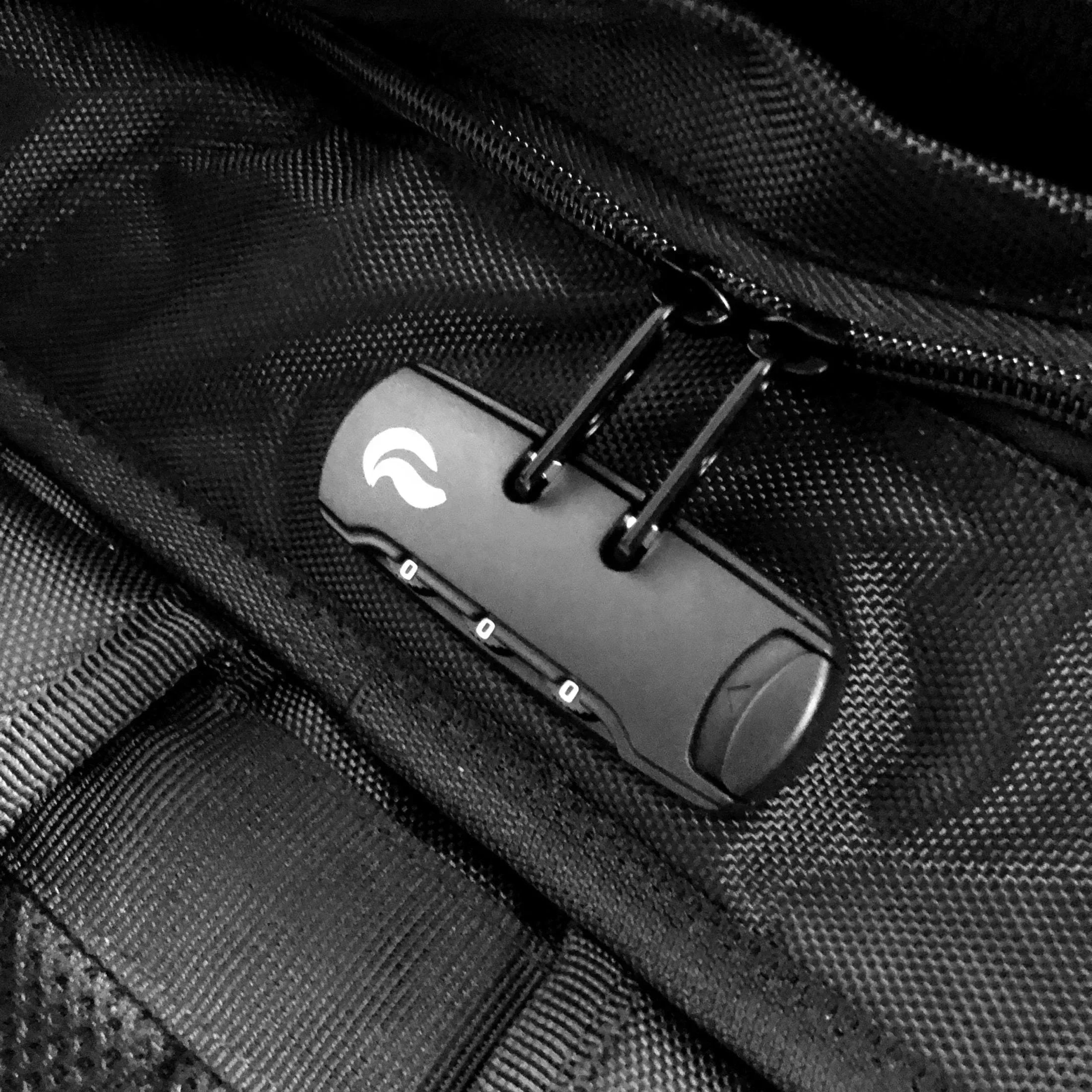 Black combination lock securing zippers on a textured travel bag