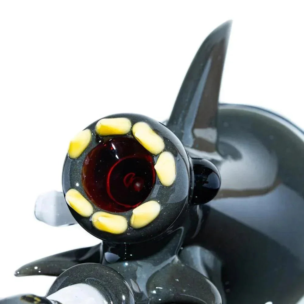 Close-up of glass shark-themed bubbler pipe with yellow teeth and fin detail
