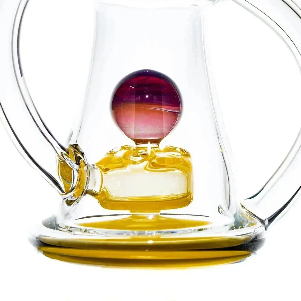 Close-up of a glass water pipe recycler featuring yellow accents and a colorful marble
